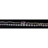 A graduated and knotted pearl single string necklace, having Art Deco white metal,