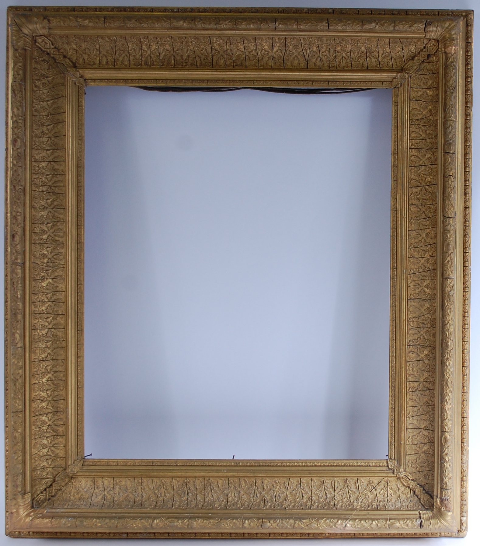 A late 19th century giltwood and gesso picture frame, the whole moulded with leaves and flowers,