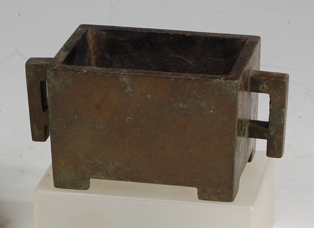 A Chinese bronze rectangular censor, having twin square handles and raised on low feet,