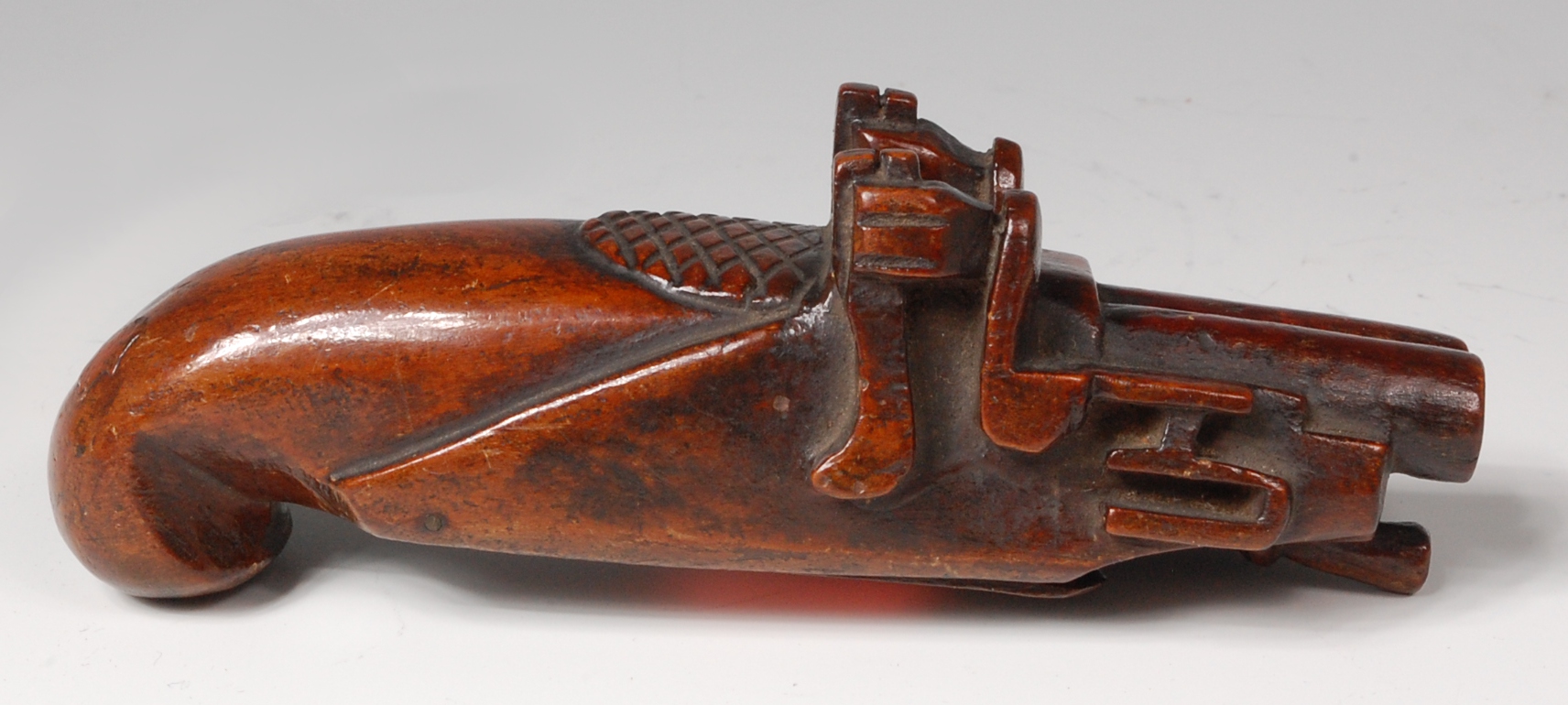 A 19th century treen snuff-box, carved as a double barreled flintlock pistol, hinged to underside,