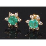 A pair of modern 14ct gold, emerald and diamond ear studs, each arranged as a flower head cluster,