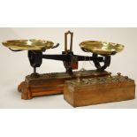 A pair of early 20th century cast iron and brass scales together with a walnut block of brass