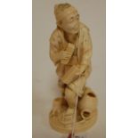 A Japanese Meiji period carved ivory okimono as a standing man,