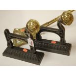 A pair of cast iron and brass mounted firedogs together with turned brass fire tools (4)