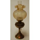 An early 20th century brass pedestal oil lamp having a filled glass shade