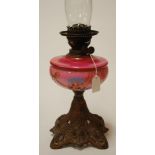 A circa 1900 pedestal oil lamp having pink glass reservoir with hand painted decoration