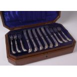 A late Victorian walnut cased canteen containing twelve place setting of silver dessert knives and