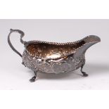 A George IV silver sauceboat, repousee decorated with C scrolls and flower heads,