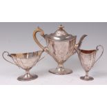 A late Victorian silver three piece teaset, in the neo-Classical style, comprising pedestal teapot,