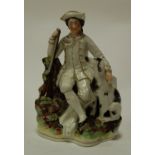 A Victorian Staffordshire figure of a seated gentleman with attendant dog
