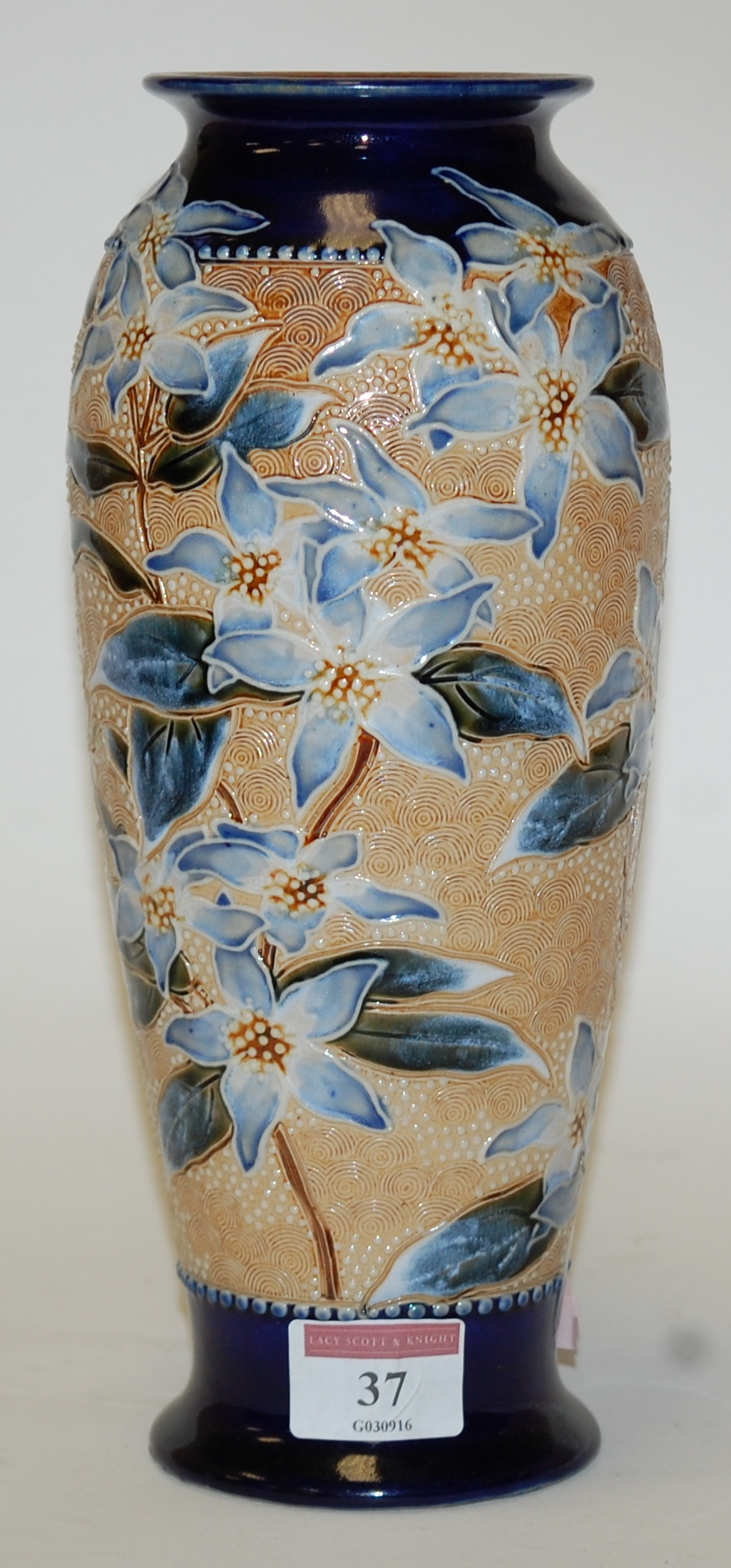 A Royal Doulton stoneware vase, of baluster form, on a blue ground with floral decoration,