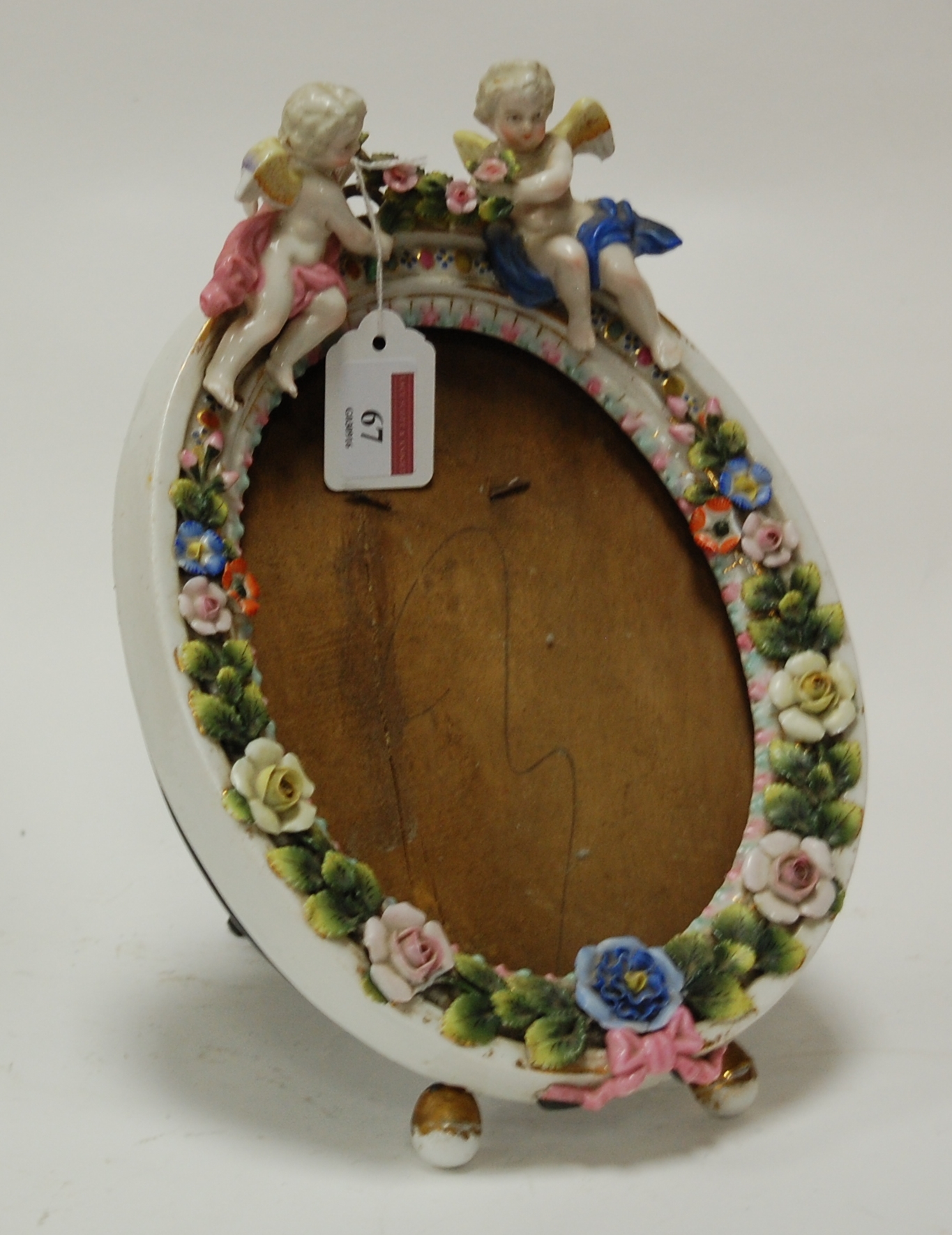 An early 20th century continental porcelain floral encrusted easel photograph frame surmounted by