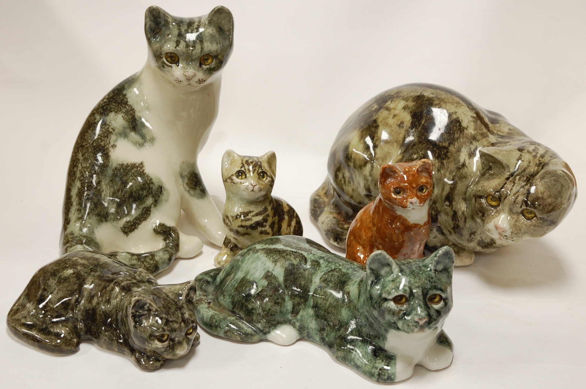 A collection of assorted ceramic cat figures to include Winstanley examples