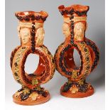 A pair of Edward Bingham Castle Hedingham pottery vase, each with four mask and inscriptions over,