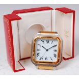 A Cartier bi-metal travelling alarm clock, having a signed white enamel dial, quartz movement,