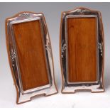 A matched pair of Art Nouveau silver photograph frames, each of shaped elongated portrait form,