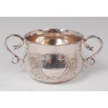 A George V hammered silver twin handled porringer, of bellied circular form,
