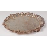 An early Victorian silver card waiter, having a C scroll and shell cast piecrust rim,