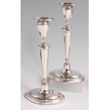 A pair of Edwardian silver candlesticks, of tapering elliptical form, on loaded bases,