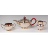 A silver three piece teaset, comprising teapot, twin handled sugar and cream,