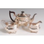 An Edwardian silver three piece teaset, comprising teapot, twin handled sugar and cream,
