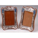 A near-pair of Art Nouveau silver and enamel photograph frames,