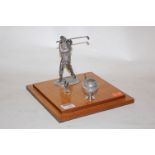 A mid-20th century desk stand, surmounted by a white metal golfer in full swing,