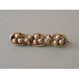 A mid Victorian yellow metal bar brooch, in the form of oval links centrally set with pellets