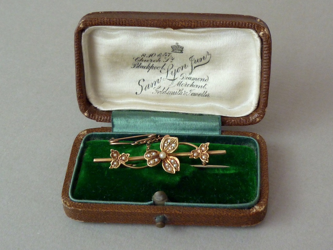 A late Victorian 15ct gold and split seed pearl bar brooch, the face surmounted by pearl set foliage - Image 2 of 2