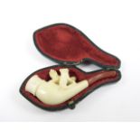 A 19th Century cased novelty meerschaum pipe, the bowl surmounted by a pair of carved dogs, with