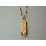 An Egyptian gold cartouche pendant, suspended on an 18ct gold fancy fetter and curb link neck chain,