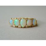 A diamond and opal dress ring, with five graded oval cabochons, the largest of which being