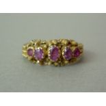 A Victorian ruby dress ring, with five graded stones rub-set to the cannetille decorated and