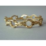 An 18ct gold bracelet, of fancy hollow links with moulded foliate decoration, 11g