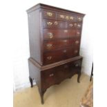 A George III oak chest on stand, having a cavetto-moulded cornice and flanking fluted quadrant-