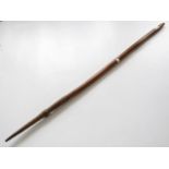 An antique ethnic slender club or digging stick, one end bound in tail hide, 118 cm