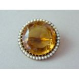 An early 20th Century citrine brooch, the circular faceted stone of approximately 21mm in