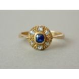 An early 20th Century sapphire and diamond dress ring, the textured circular face centrally collet