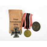 A German Third Reich second class Iron Cross, a War Merit medal and envelope, and a black wound