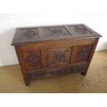 A 1920s Arts and Crafts influenced carved oak mule chest, of three-panel construction, the profuse