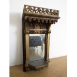 A Victorian parcel-gilt carved oak bracket mirror in the manner of Pugin, having a gothic canopy