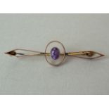 An early 20th Century amethyst geometric openwork bar brooch, with central millegrain set stone held