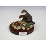 A Border Fine Arts figurine of otter cubs with a crab