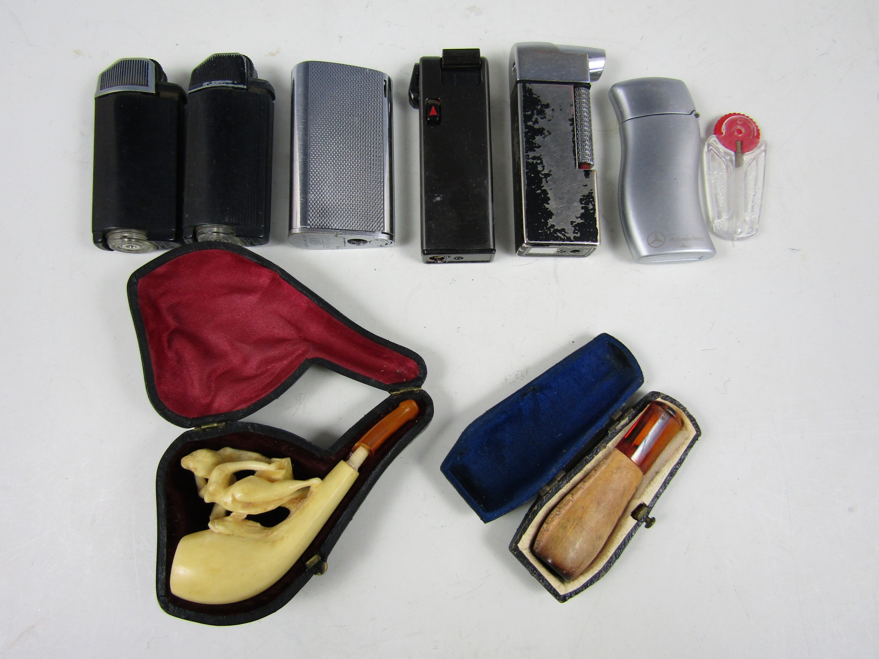 Six lighters together with a cased cheroot holder and a cased pipe (a/f)