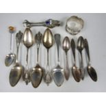 A silver napkin ring, silver sugar nips and a selection of ornate tea and coffee spoons