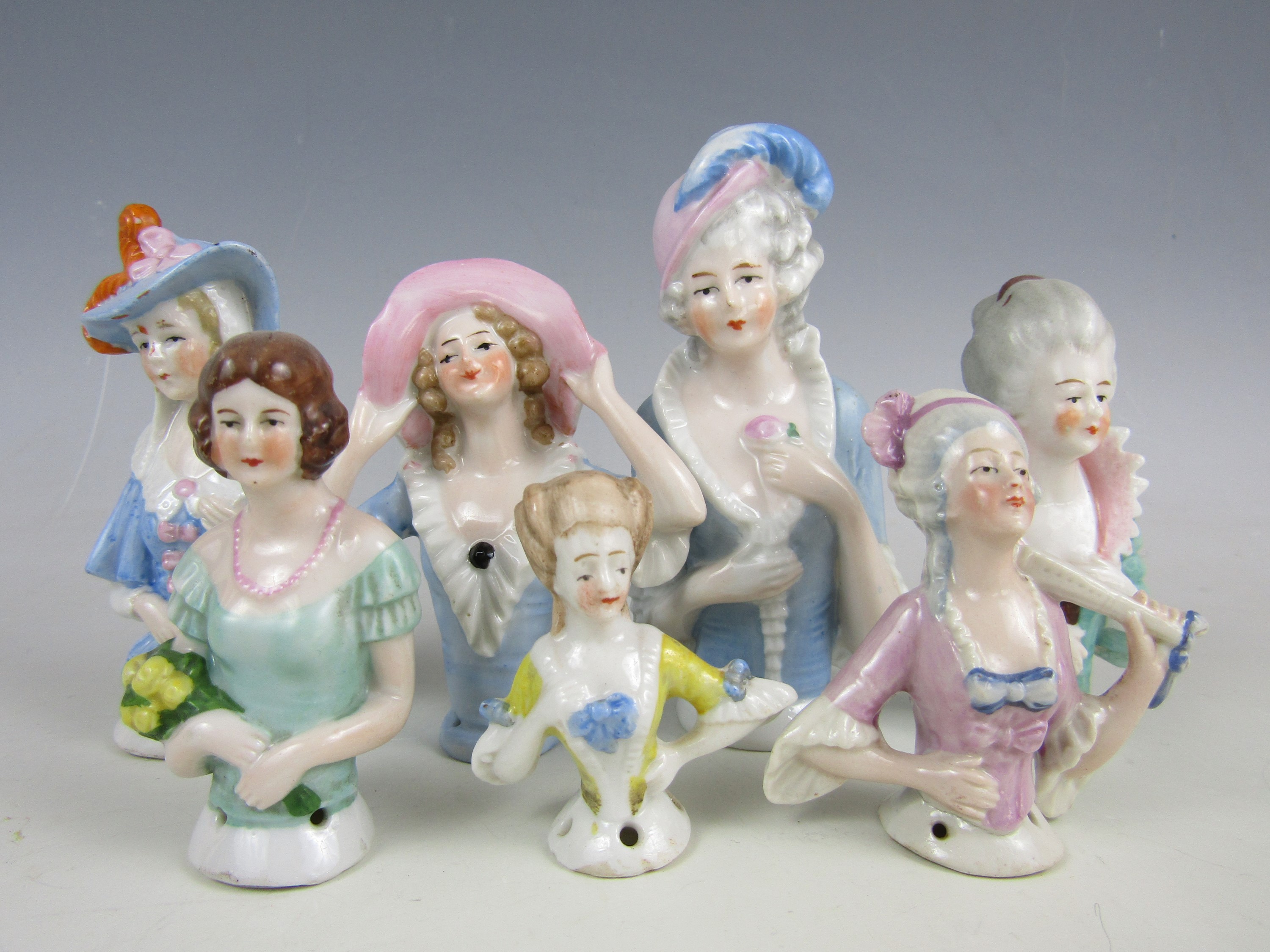 A collection of porcelain pin ladies