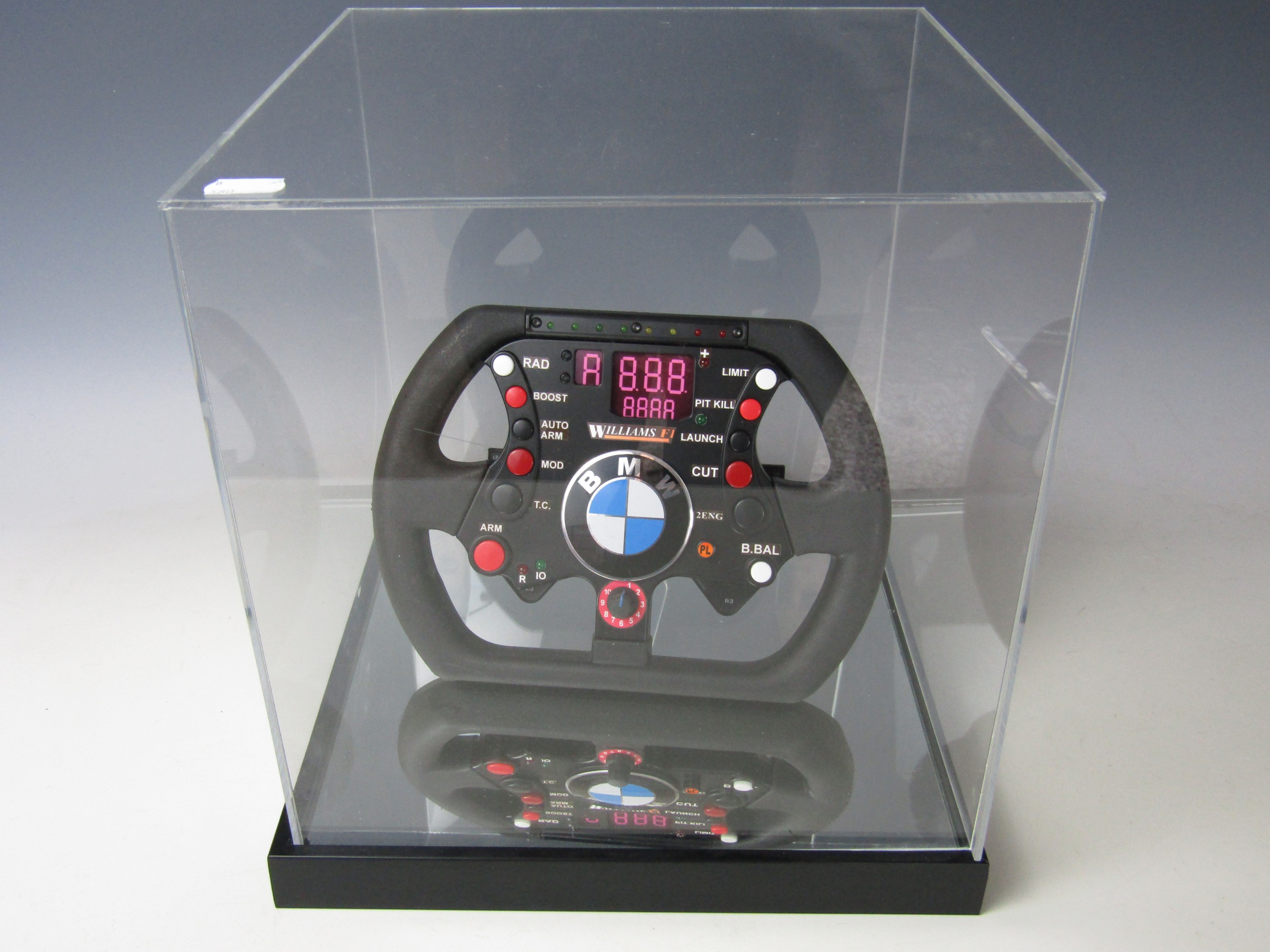 A cased replica Williams Formula 1 steering wheel, 32 x 32 x 33 cm