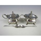 A pair of George V silver mustard pots, with cobalt blue glass liners and silver spoons, Robert