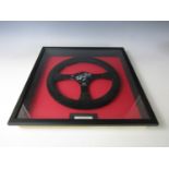 A framed replica Formula 1 steering wheel signed by Alain Prost