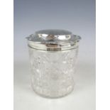 An Edwardian silver mounted cut glass dressing table box, of cylindrical form, wheel cut in an